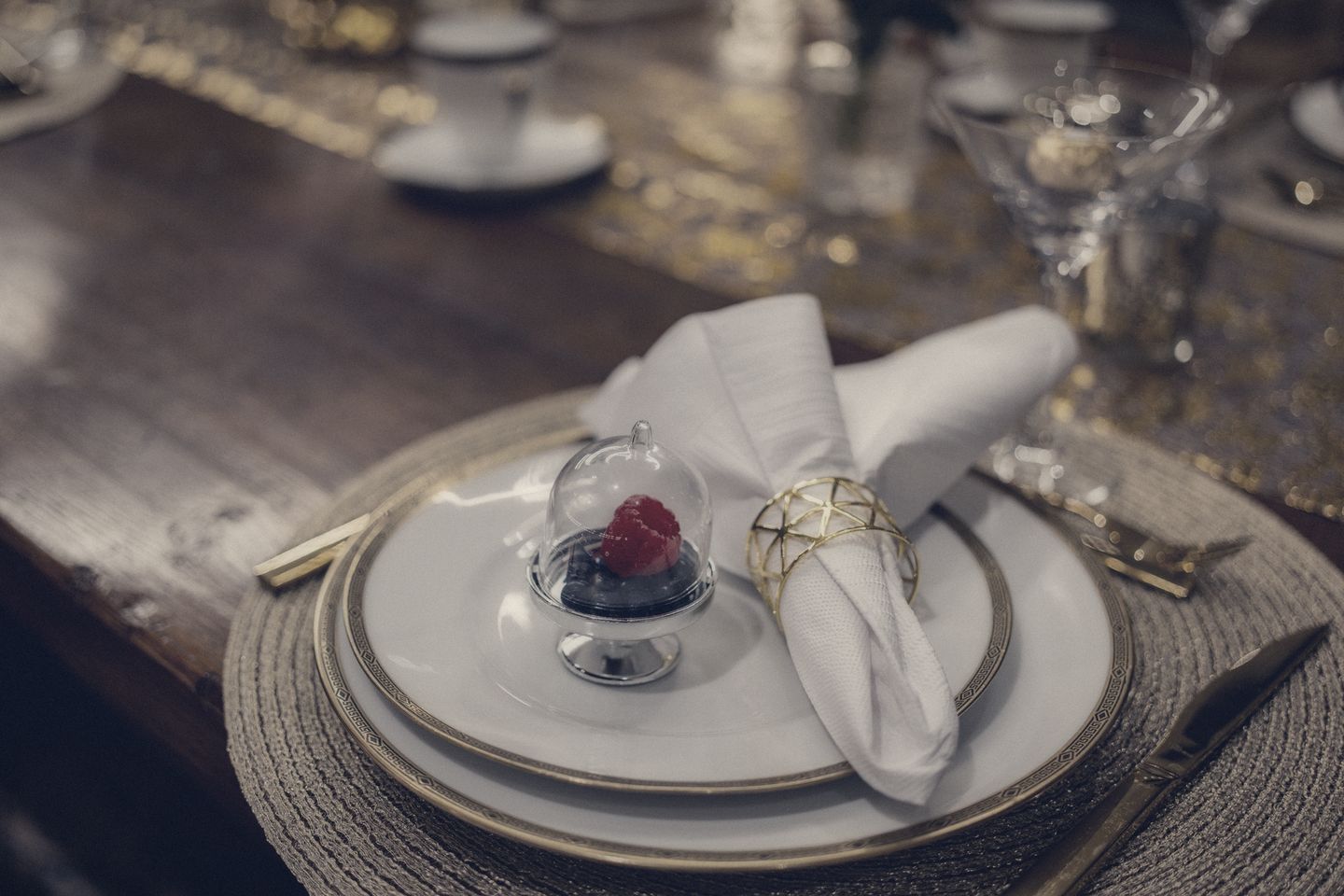 Festlich gedeckter Tisch mit Gold, Porzellan und Blumen
