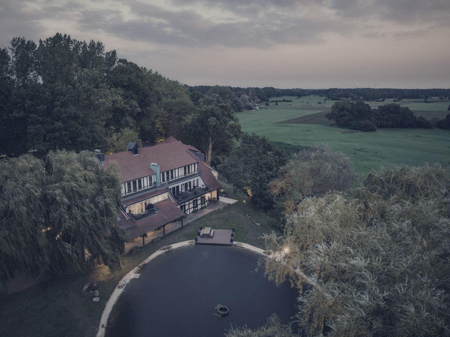 Der Schlossteich in der Abenddämmerung, von oben gesehen, mit dem Anwesen dahinter